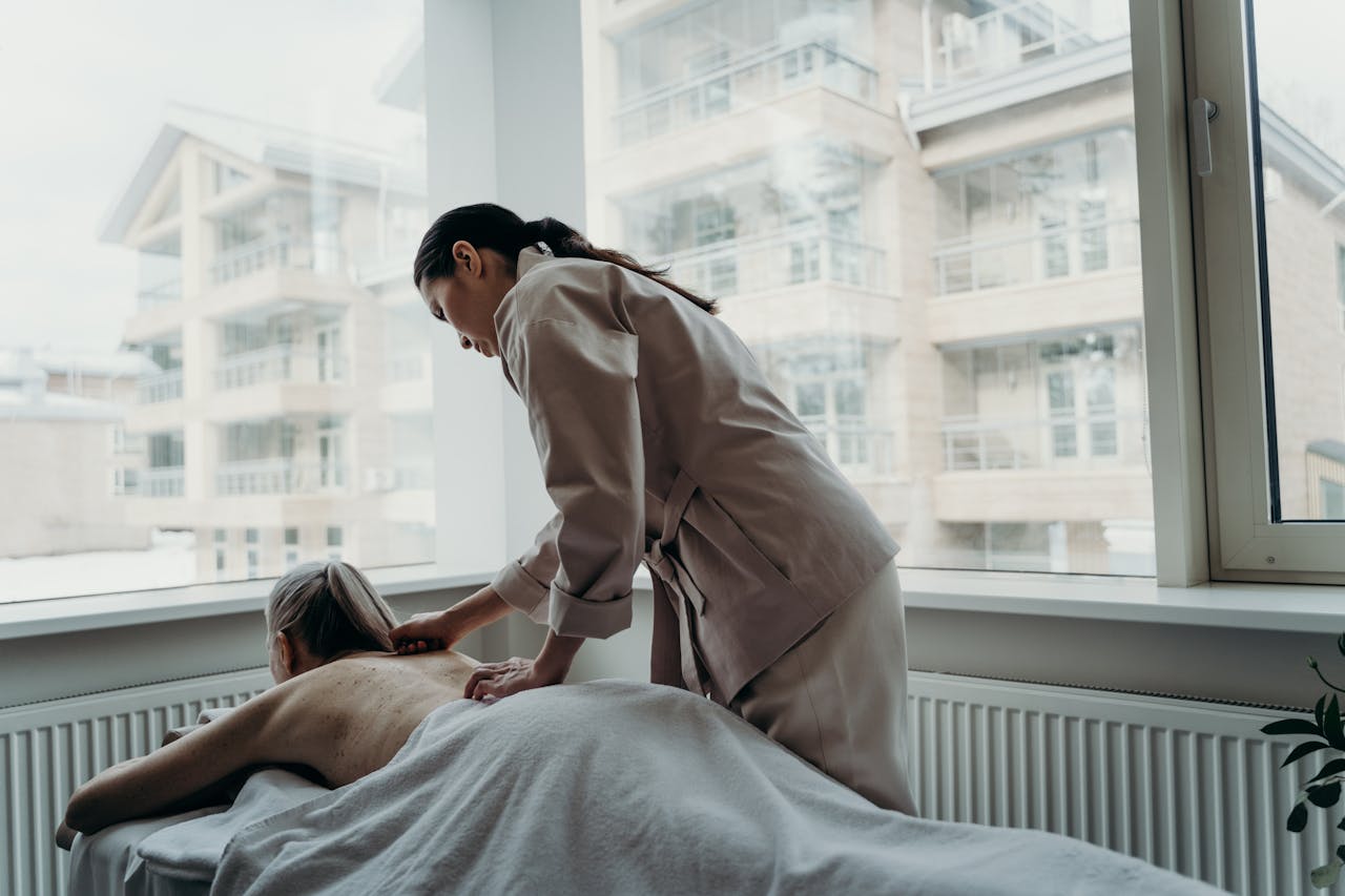 Woman receiving a back massage in a spa, promoting relaxation and wellness.